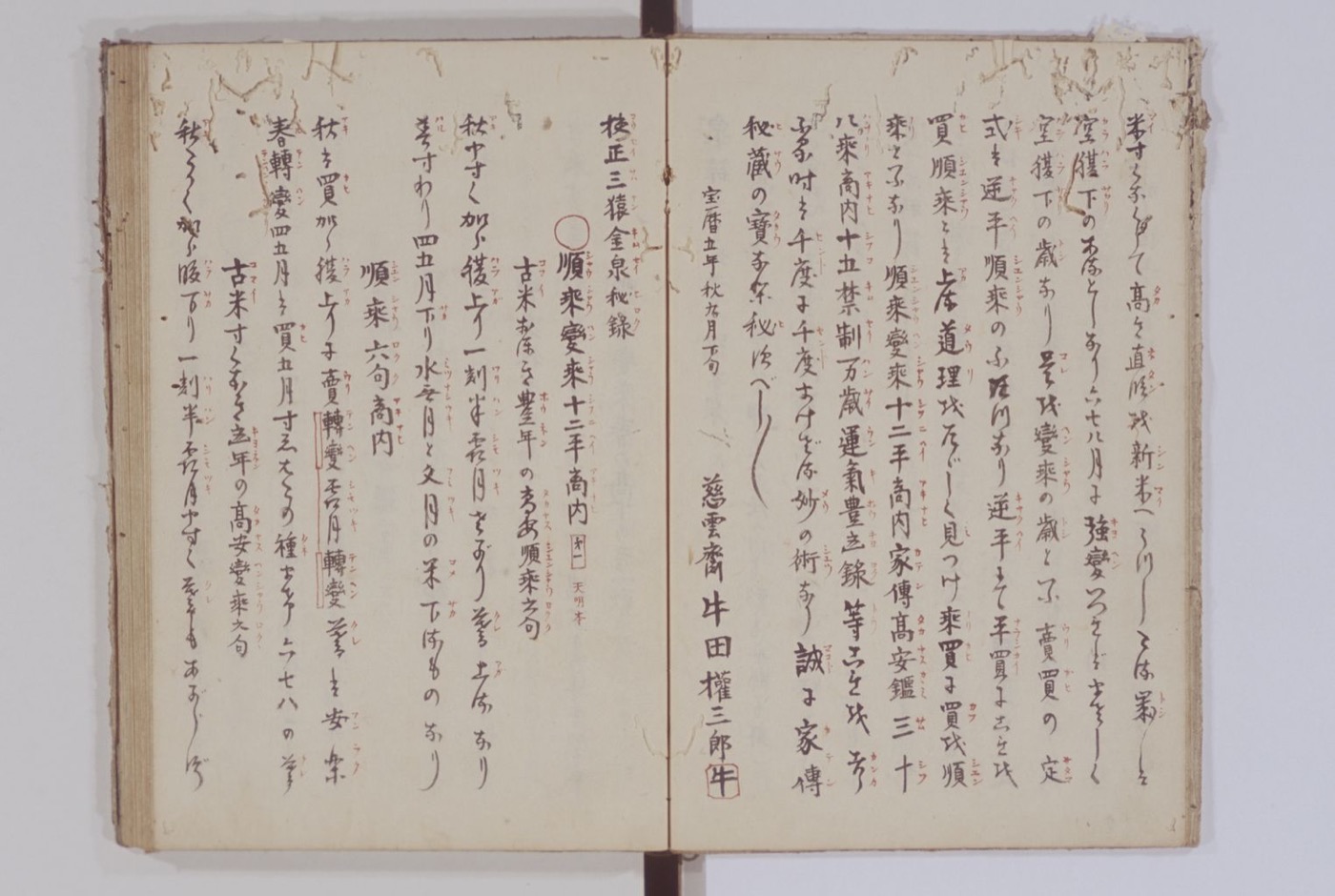 A handwritten manuscript opening in cursive brush script, with red reading marks between the columns and a red ownership seal beside the author's name at lower centre